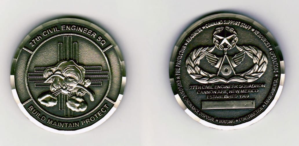 Round shaped, pewtered colored, black edged coin 1-1/2 inches in diameter.