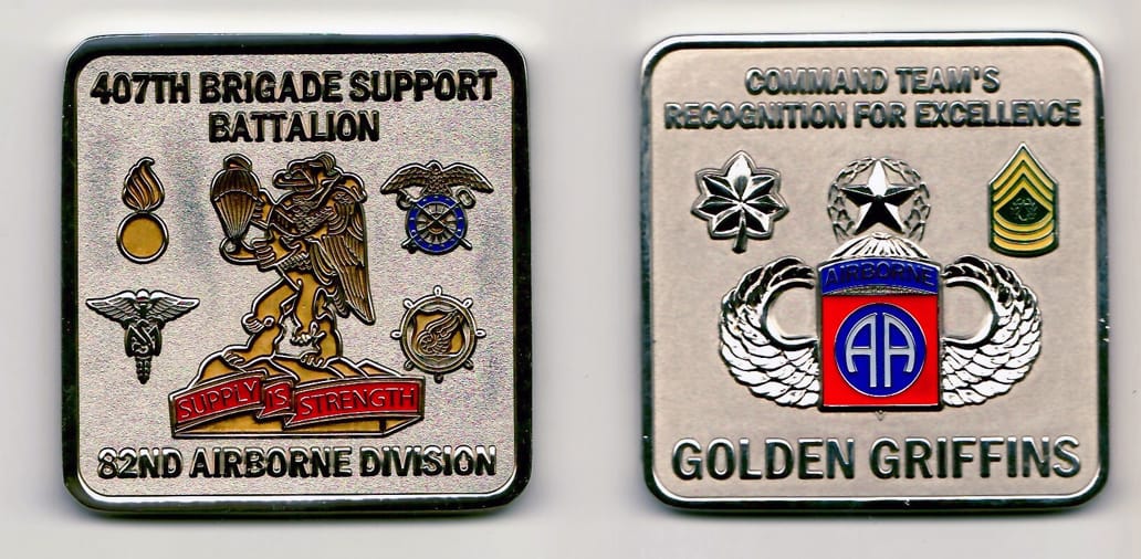 Square shaped, silver colored coin 2-1/8 inches wide x 2-1/8 inches high.