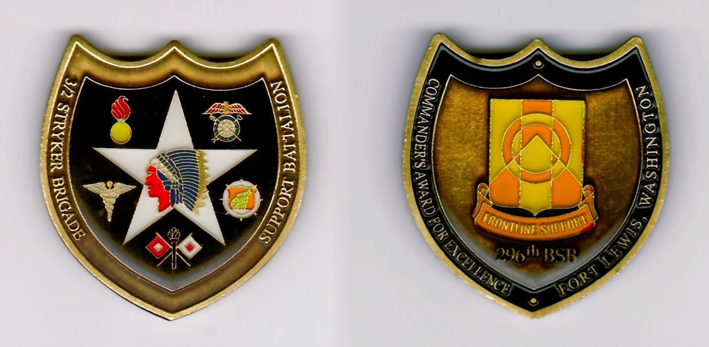 Shield shaped, antique brass colored coin 1-7/162 inches iwide x 2 inches high.