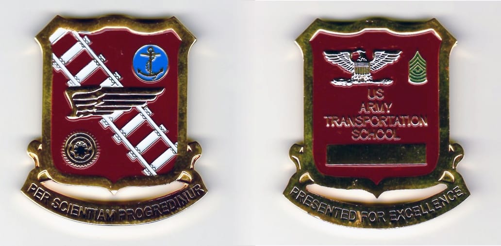 Squared off-shield shaped, gold colored coin, with attached banner beneath, 1-3/16 inches wide x  2 inches high.