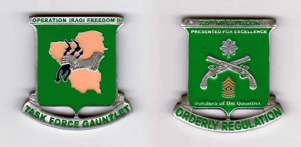 Squared off-shield shaped, pewter colored coin, with attached banner beneath, 1-3/4 inches wide x  1-3/4 inches high.