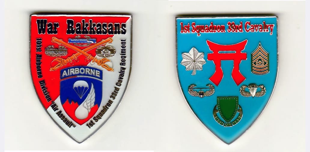 Shield shaped, white gold colored coin 1-9/16 inches wide x 2 inches high.