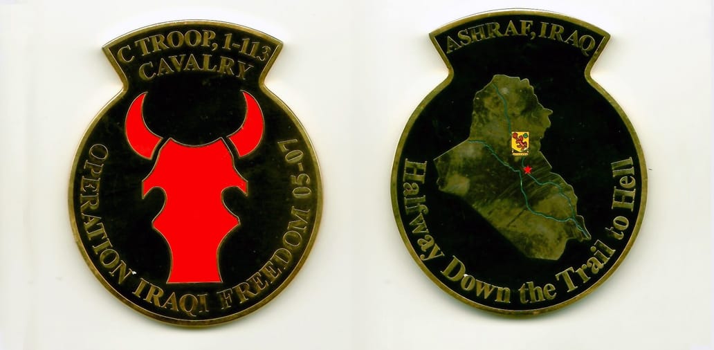 Round shaped with top curved extension piece, brass colored coin 2-1/4 inches wide x 2-3/4 inches high.