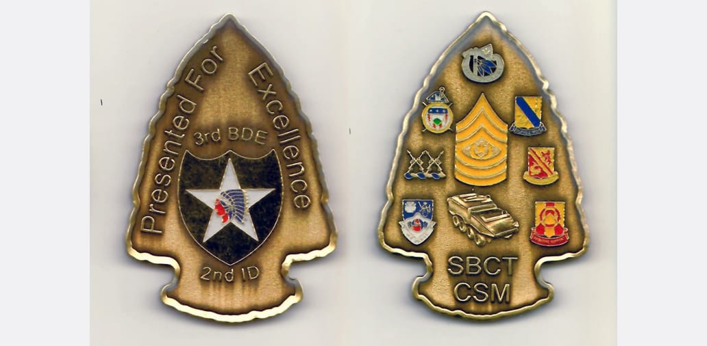 Arrowhead shaped, antique brass colored coin 1-15/16 inches wide x 2-3/4 inches high.