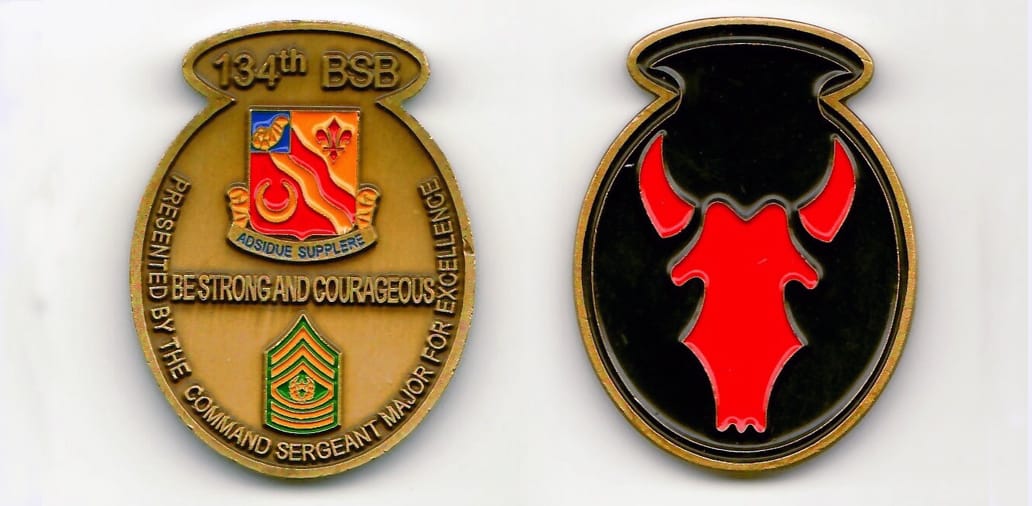 Oval shaped with curved piece attached on top, brass colored coin 1-1/2 inches wide x 1-15/16 high.