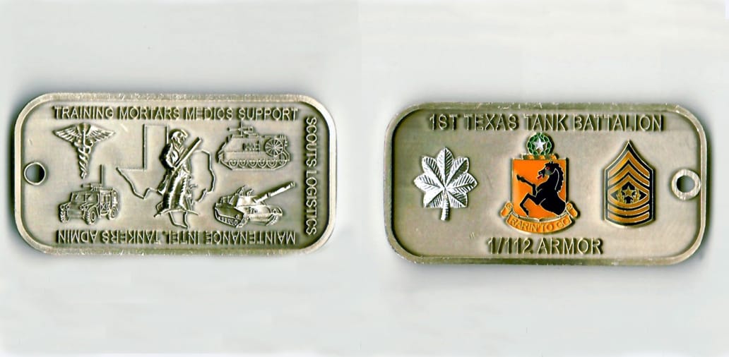 Dog tag shaped, light brushed gold colored coin 2-1/2 inches wide x 1-1/4 inches high.