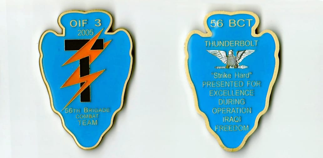 Arrowhead shaped, gold colored coin 1-9/16 inches wide x 2-1/4 inches high.