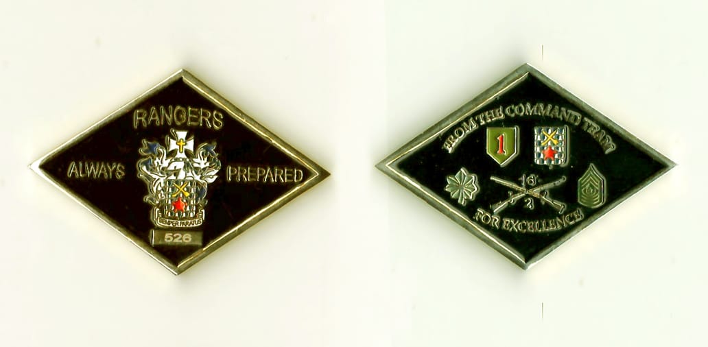 Diamond shaped, gold colored coin, 1-15/16 iches wide x 1-5/16 inches high.