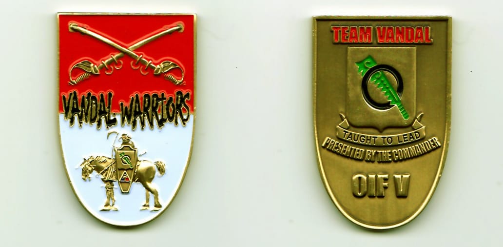 Shield shaped with rounded bottom, brass colored coin, 1-5/16 inches wide x 2 inches high.