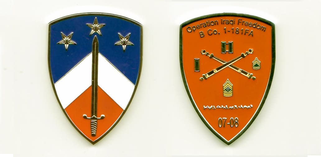 Shield shaped, silver colored coin, 2 inches high x 1-1/4 inches wide.