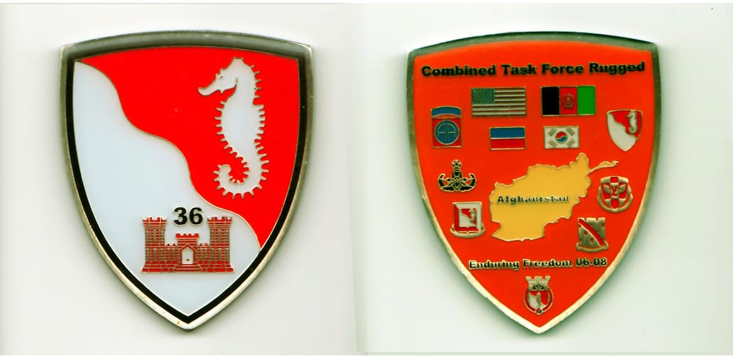 Shield shaped, pewter colored coin, 2-1/2 inches high x 2 inches wide.