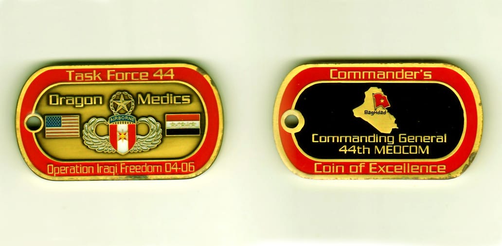 Dog tag shaped, gold colored coin, 1-3/8 inches high x 2-1/2 inches wide.