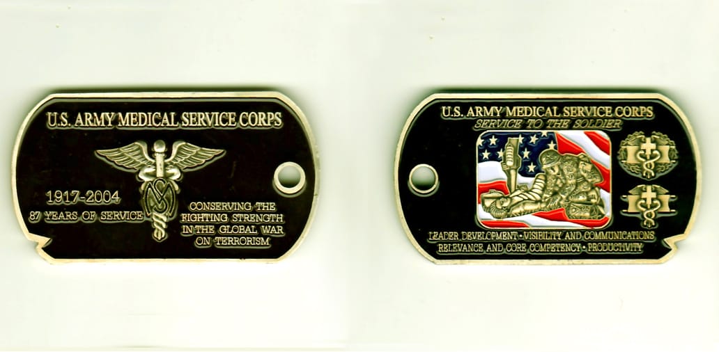 Dog tag shaped, antique gold colored coin, 1-1/2 inches high x 2-11/16 inches wide.