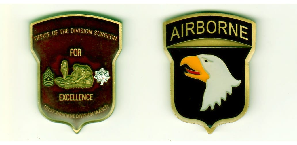 Shield shaped, with banner above, antique gold colored coin, 2 inches high x 1-1/2 inches wide.