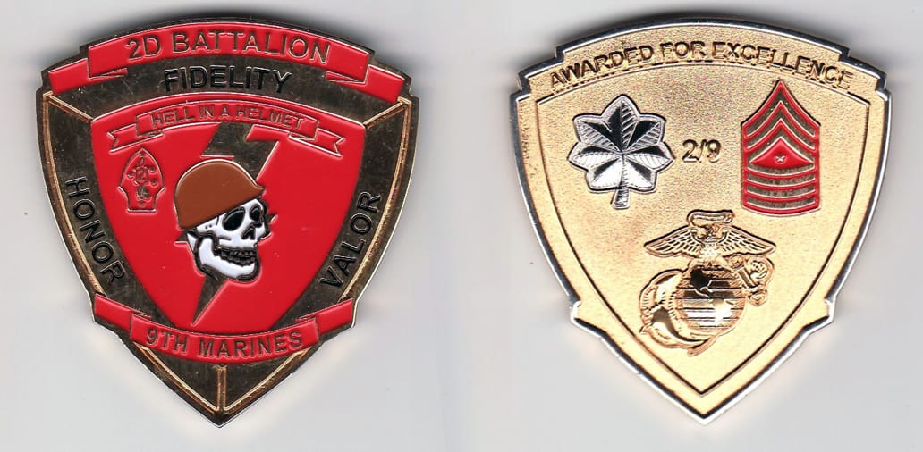 Shield shaped, gold colored coin, 1- 15/16 inches wide x 2 inches high.