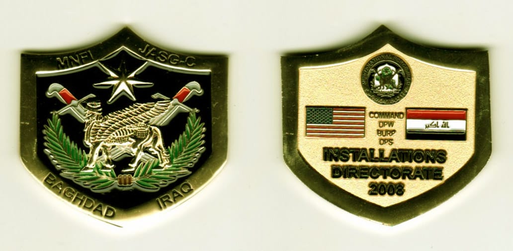 Shield shaped, gold colored coin, 1-3/4 inches wide x 1-1/2 inches high.