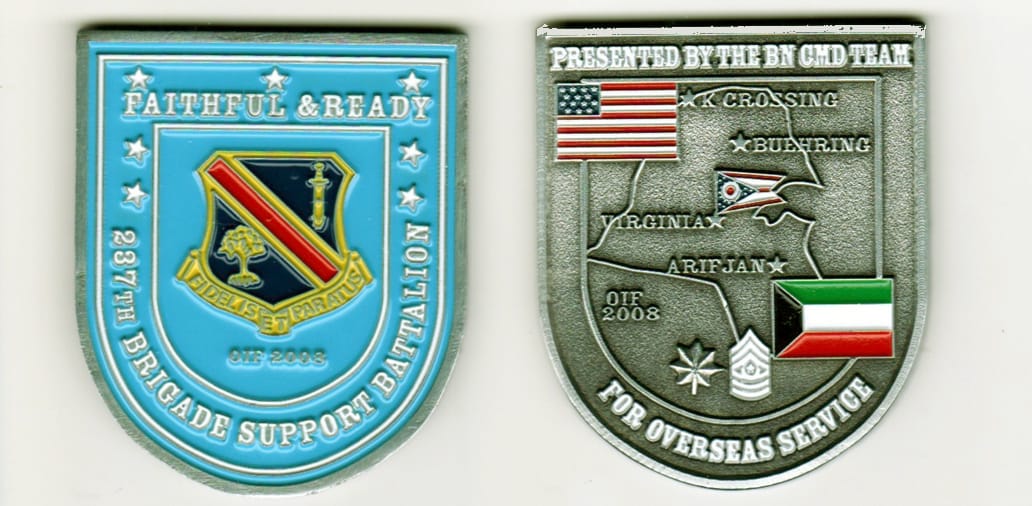 Shield shaped, pewter colored coin, 2- inches high by 1- 1/2 inches wide.