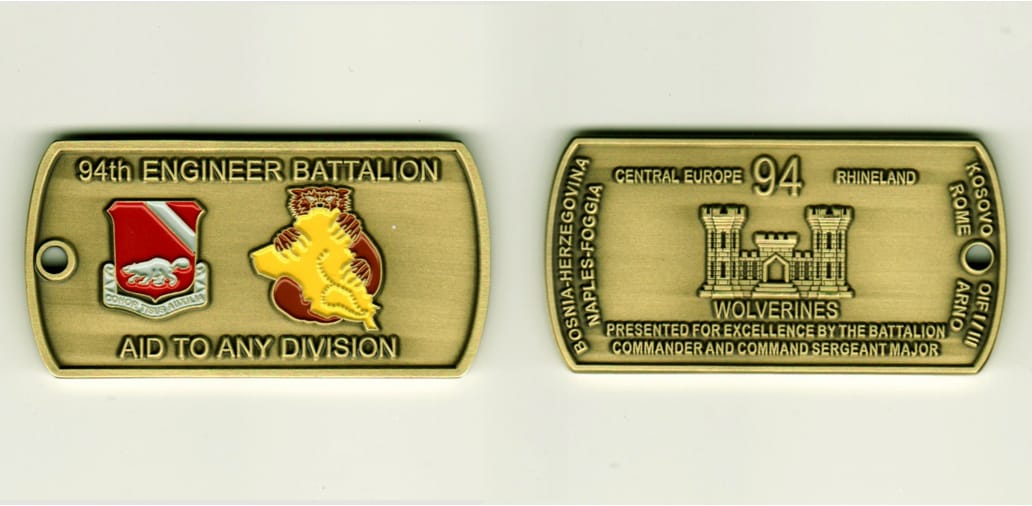 Dog tag shaped, antique brass colored coin, 2-3/4 inches wide x 1 inch high.