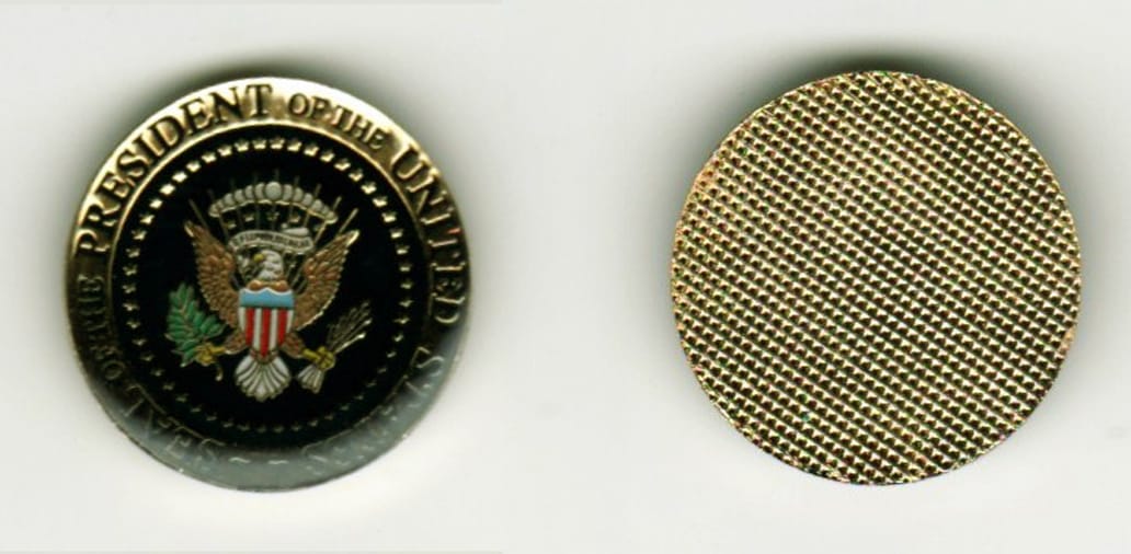 Round shaped, gold colored coin, 1 inch in diameter.