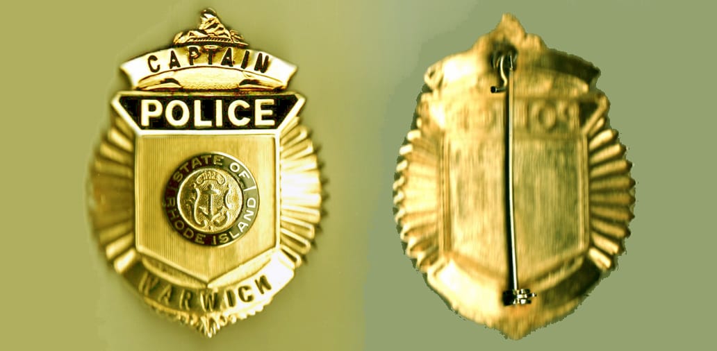 Oval shaped, gold colored police badge, 2 inches wide x 2 /3/4 inches high.