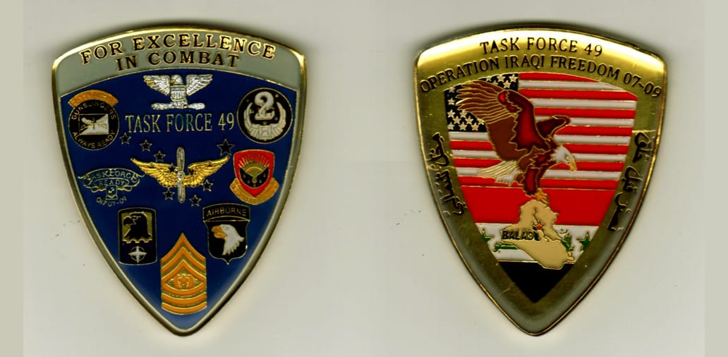 Shield shaped, gold colored coin, 2 inches iwide x 2 1/2 inches high.