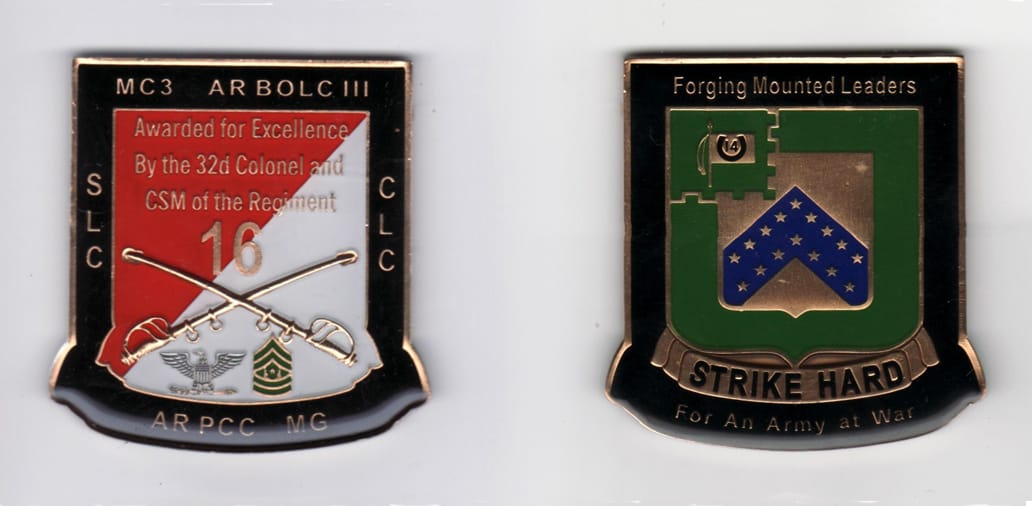 Shield shaped with squared off bottom, brass colored coin, 2 1/2 inches wide x 2 1/2 inches high.