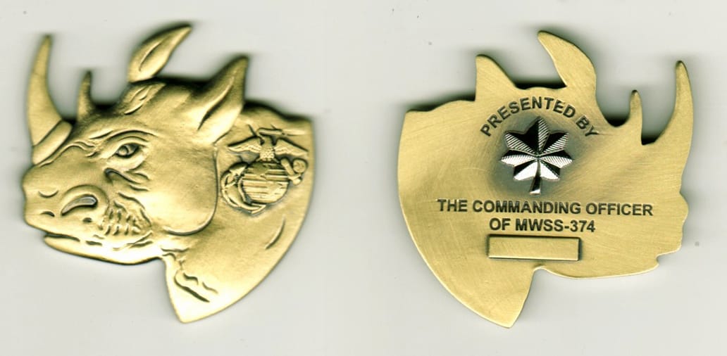 Rhino's head shaped, brass colored coin, 1 14/16 inches wide x 2  inches high.