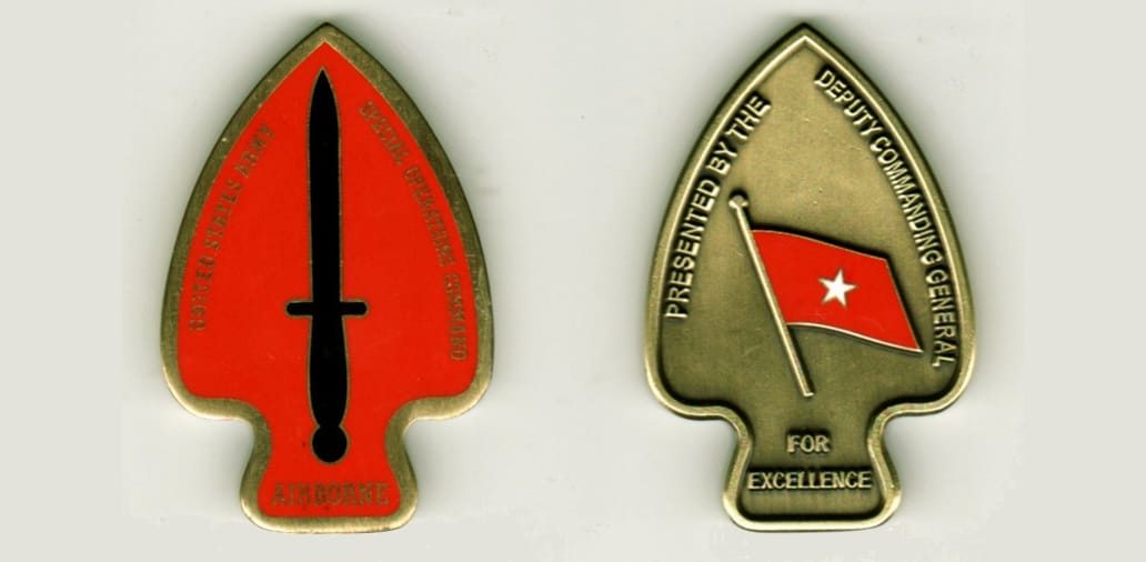 Arrowhead shaped, brass colored coin, 1 1/16 inches wide x 2 inches high.