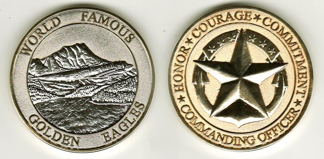 Round shaped, pewter colored coin with gold colored edge, 2 1/8 inches in diameter.