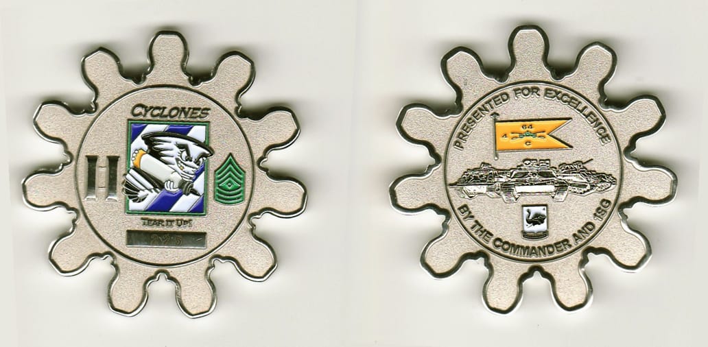 Round  cog shaped, silver colored coin 2 inches in diameter.