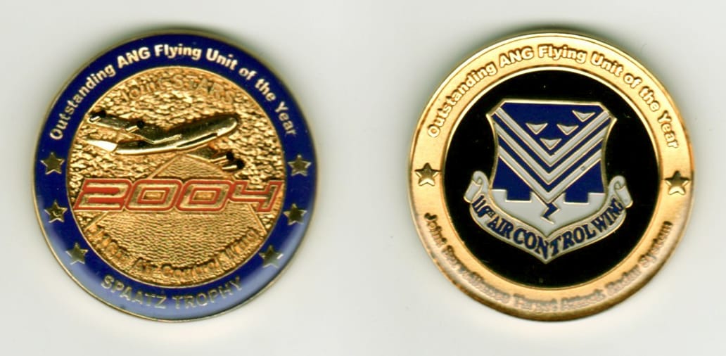 Round shaped, gold colored coin, 1 1/4 inches in diameter.