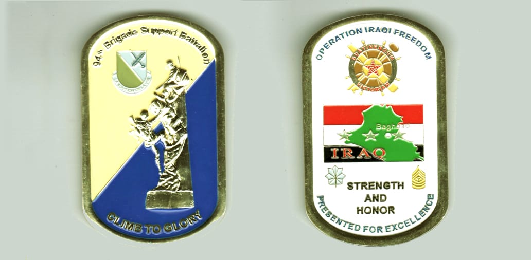 Dog tag shaped, gold colored coin, 2 inches wide x 3 1/4 inches high.