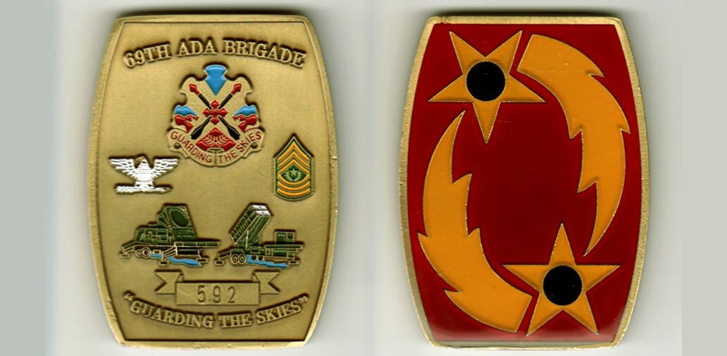 Retangular shaped with bowed sides, brass colored coin, 1 3/4 inches wide x 2 1/2 inches high.