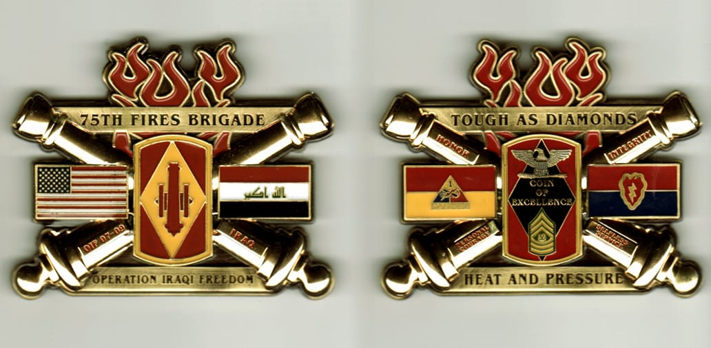 Retangular shaped with cannons extended and flames mounted above, brass colored coin, 3 inches wide x 2 1/2 inches high.