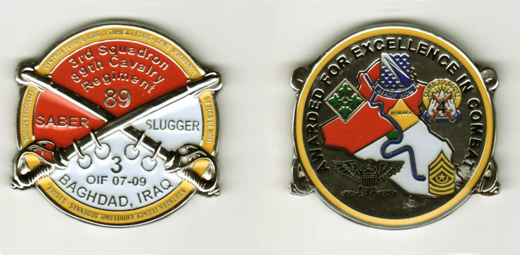 Round shaped with ends of crossed cavalry swords protuding, silver colored coin, 1 11/16 inches in diameter.