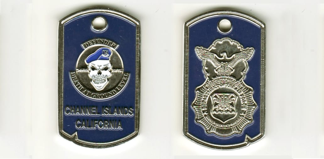 Dog tag shaped, silver colored coin, 1 inch wide x 2 inches high.