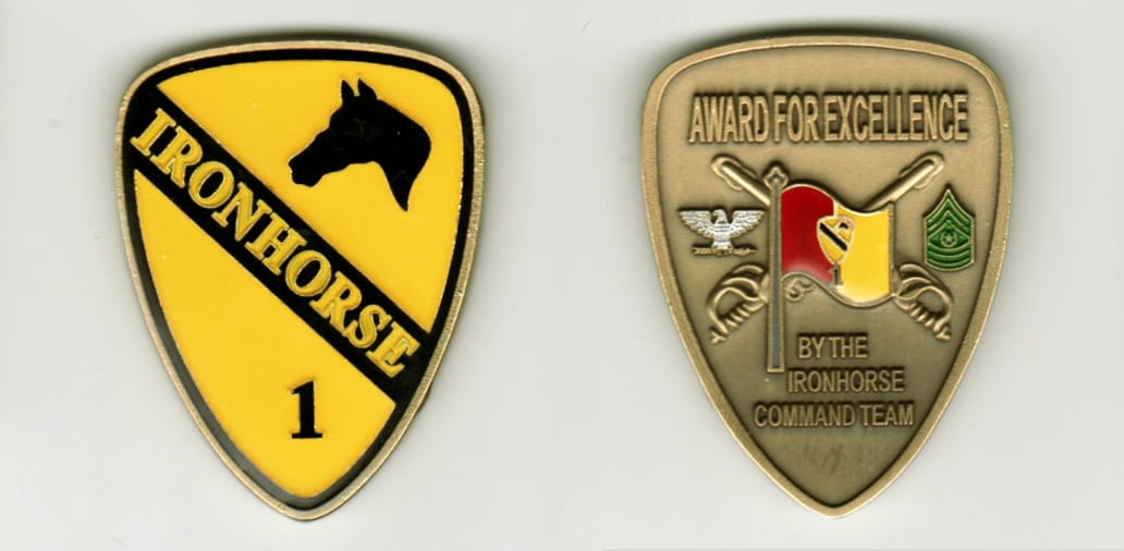 Shield shaped, antique brass colored coin, with rounded top, 2 inches high x 1-1/2inches wide.