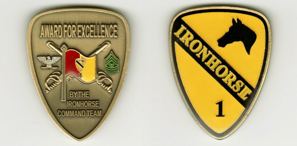 Shield shaped, antique brass colored coin, with rounded top, 2 inches high x 1-1/2inches wide.