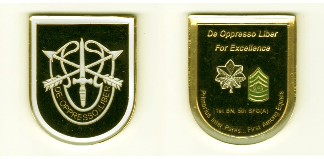 Shield shaped, gold colored coin, 1 1/2 inches wide x 2  inches high.