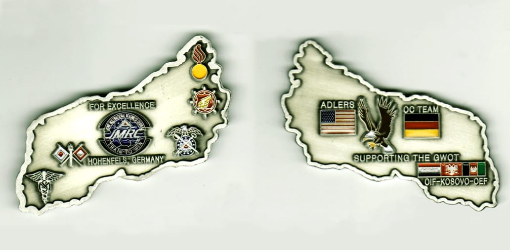 Irregular shaped (country or area), silver colored coin, 2 3/4 inches wide x 2 inches high.