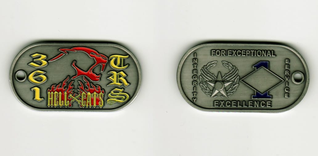 Dog tag shaped, pewter colored coin, 2  inches wide x 1 inch high.