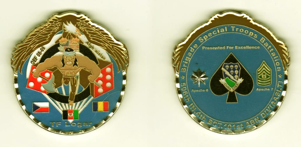 Round shaped with spread wings mounted on top, gold colored coin, 2 inches high x 1 7/8 inches wide.