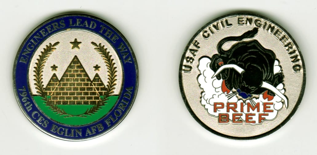 Round shaped, silver colored coin, 1 11/16  inches in diameter.