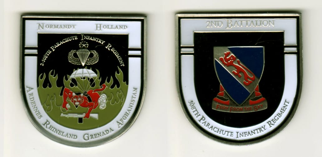 Shield shaped, pewter colored coin, 2 inches high x 1 7/8 inches wide