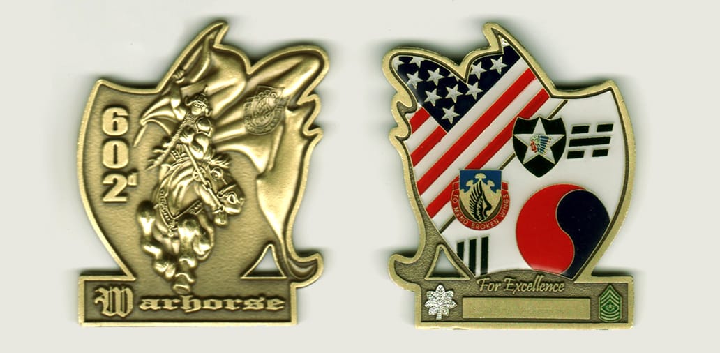 Shield shaped with sign mounted below and windblown cape extended from right side, brass colored coin, 2 inches high x 2...