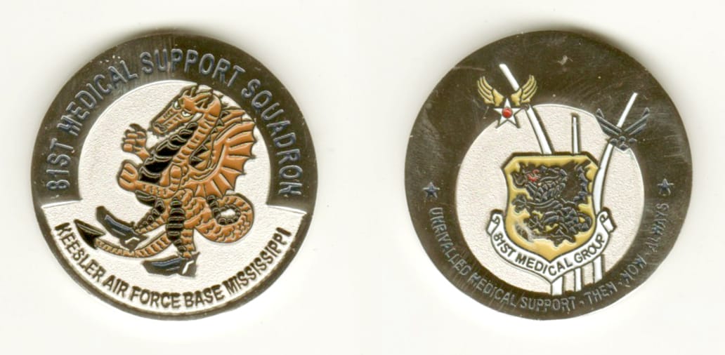 Round shaped, silver colored coin, 1 1/2 inches in diameter.