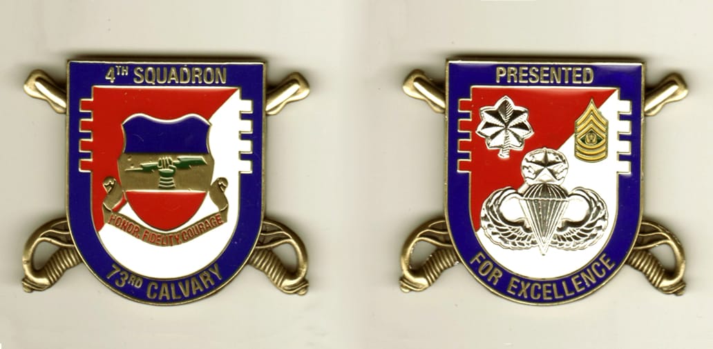 Shield shaped with crossed Cavalry swords extending, brass colored coin, 1 15/16 inches high x 2 1/4 inches wide.