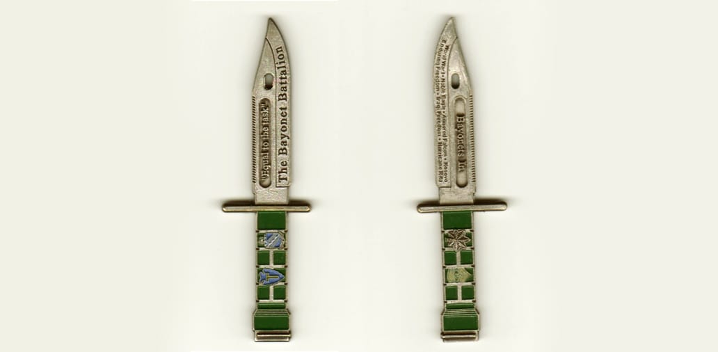 Bayonet shaped, silver colored coin, 2 3/4 inches high x  3/4 inch wide.