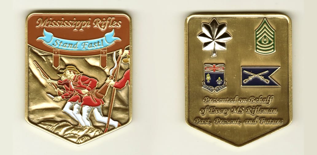 Shield shaped, brass colored coin, 2 1/2  inches high x 2 inches wide.