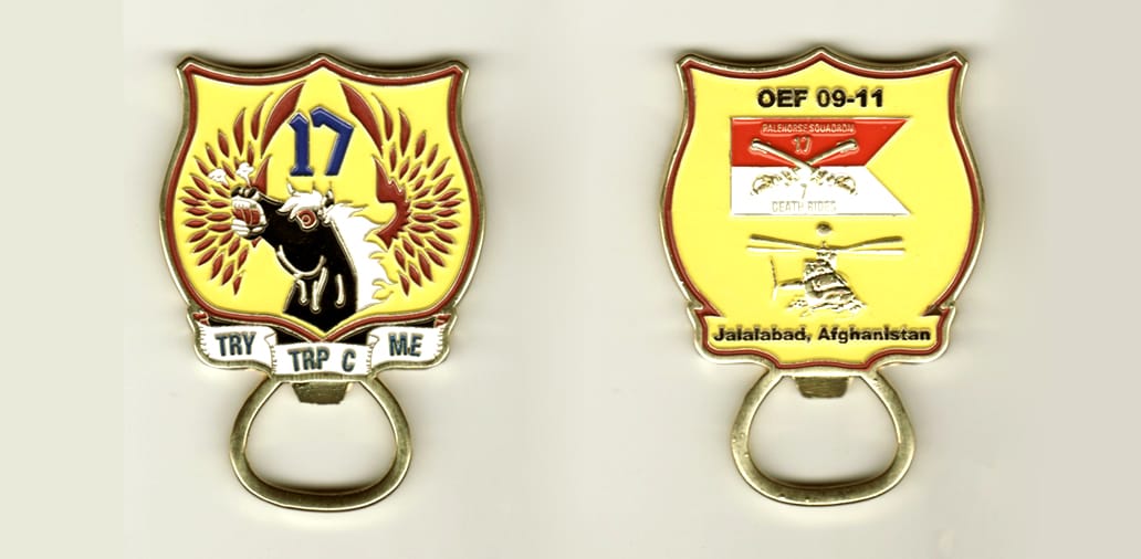 Shield shaped with circular shaped bottle opener mounted below, brass colored coin, 2 1/2 inches high x 2 inches wide.